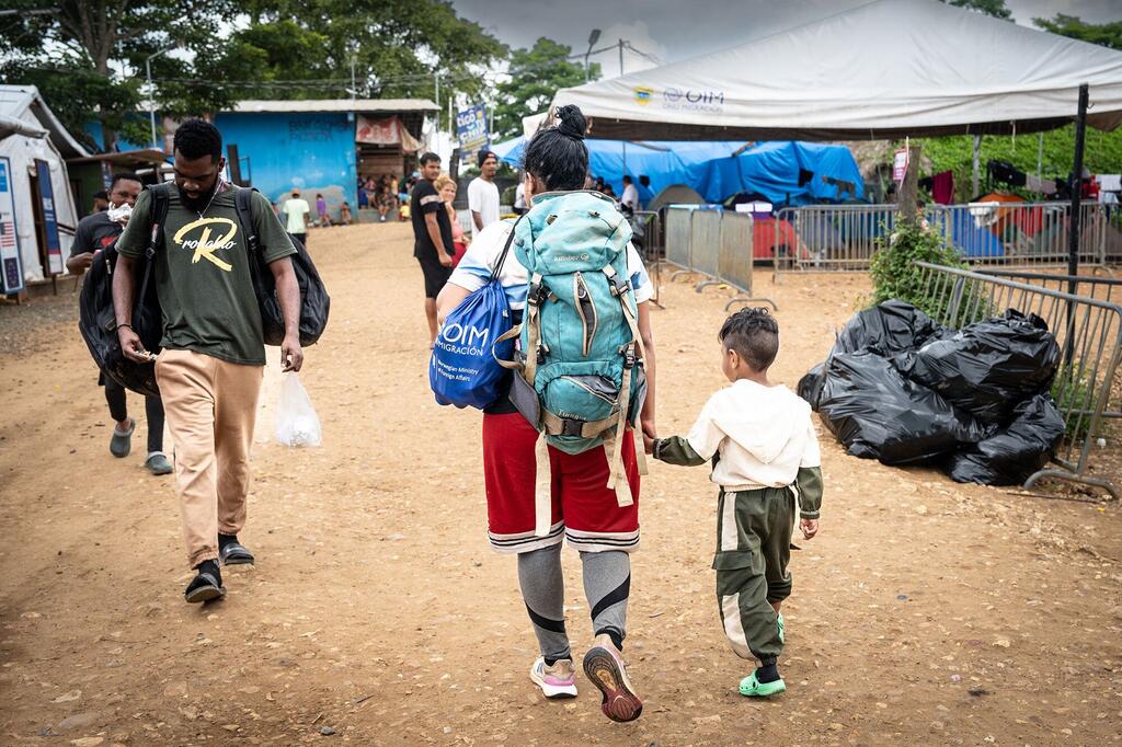 A migrant woman with a child walks to a reception centre in Central America. (file photo)